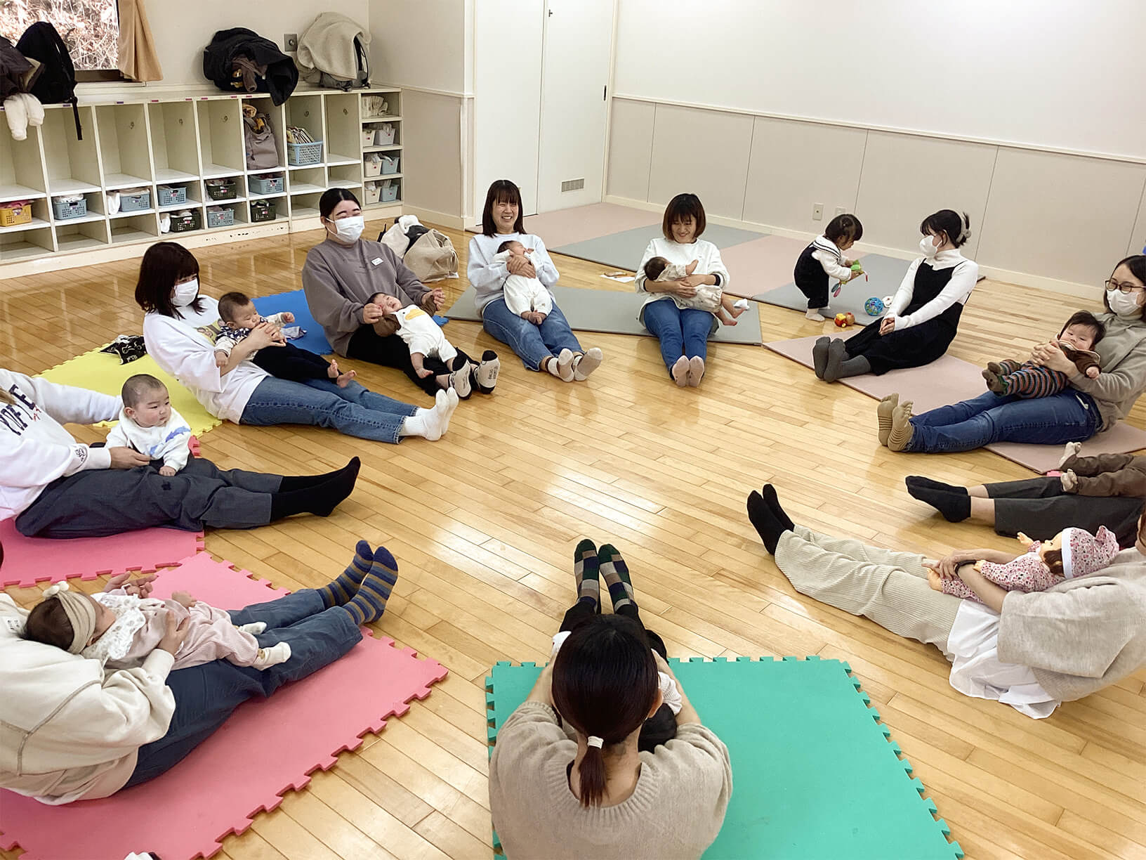 円になって集まる数組の親子